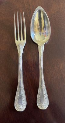two spoons and a fork sitting on a table