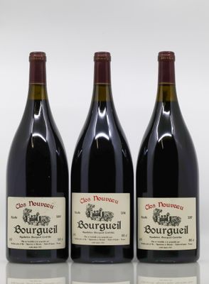 trois bouteilles de vin rouge posées sur une table blanche