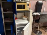 un petit réfrigérateur dans un coin de la pièce