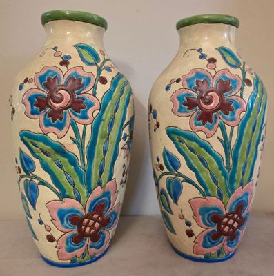 deux vases avec des fleurs peintes dessus, posés sur une table