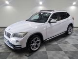 Le SUV BMW blanc est garé dans une grande pièce