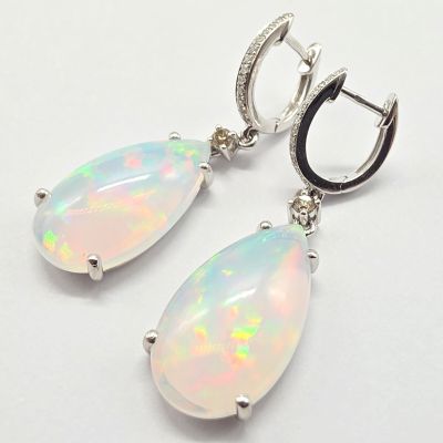 une paire de boucles d'oreilles en oplite et diamants sur fond blanc