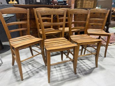 four wooden chairs sitting next to each other in a room
