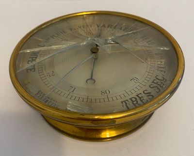 a gold clock on a white table with a white background