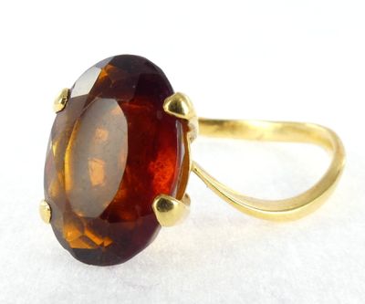 a picture of a ring with a large brown stone