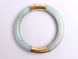 jade bangle bracelet with gold accents on a white background