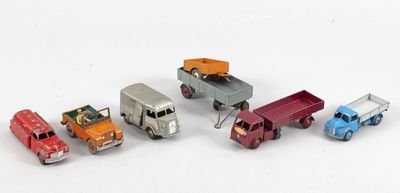 plusieurs camions jouets sont alignés sur une surface blanche