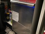 un lave-vaisselle en acier inoxydable dans une cuisine, à côté d'une poubelle