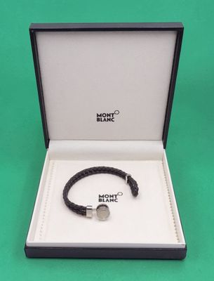 un gros plan d'un bracelet dans une boîte posée sur une surface verte