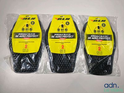 trois sacs contenant des objets noirs et jaunes posés sur une surface blanche