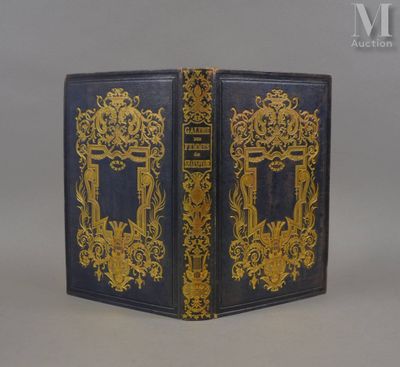 un vieux livre à la couverture dorée et bleue posé sur une table