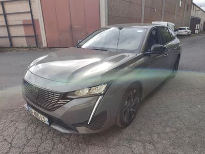 La voiture est garée sur le bord de la route, devant un immeuble.
