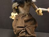 a doll that is dressed like a man with a sword