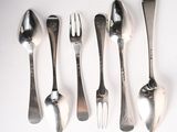 five spoons and a fork on a table