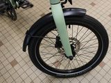 a green bike parked in a room with a tiled floor