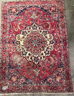 an antique persian rug with a medallion design on a red ground