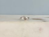 une photo d'une bague en diamant posée sur une surface en marbre