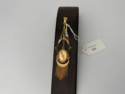 a gold clock on a black tie with a tassel hanging from it