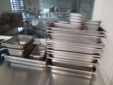 several stainless steel pans are lined up on a table
