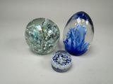 trois billes de verre posées sur une table l'une à côté de l'autre