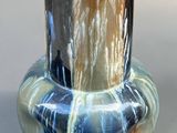 un vase posé sur une table à fond gris