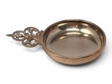 a close up of a metal bowl with a handle on a white background