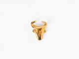 un gros plan d'une bague en or ornée d'une tête de taureau