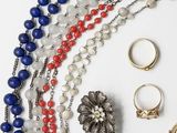 many different types of necklaces and rings on the table