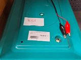 une boîte en plastique bleue surmontée d'un cordon rouge