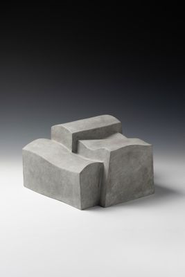 un gros plan d'un objet en béton posé sur une surface blanche