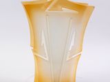 vase en verre jaune avec un couvercle blanc, posé sur une surface blanche