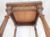 a small wooden table with a gold decoration on top of it