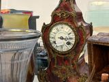 une table en verre sur laquelle se trouvent une horloge et une bouteille de vin