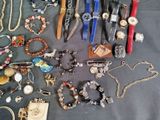 many different types of watches and bracelets laid out on a table