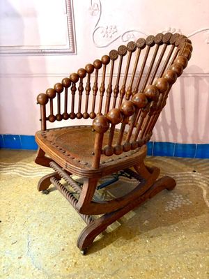 un fauteuil à bascule en bois dans une pièce aux murs roses
