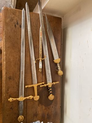 plusieurs couteaux accrochés à un mur en bois dans une pièce