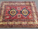 a red and blue rug on a gray surface