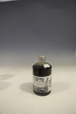 a bottle of liquor sitting on a counter next to a glass of wine