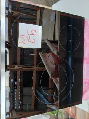 a black stove top with a glass door and a sign on it