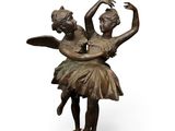 statue of a couple of dancers on a pedestal on a white background