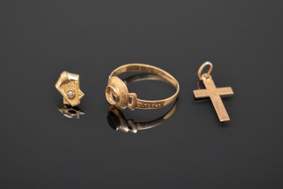 trois anneaux dorés et une croix sur un fond noir