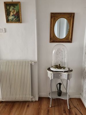 une petite table sur laquelle est posé un miroir, dans un coin de la pièce