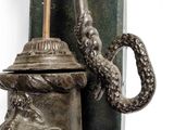 a statue of a man holding a pipe with a snake on it