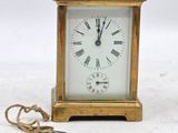 une petite horloge en or entourée d'une chaîne