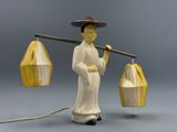 a figurine of a man holding a bamboo basket and a stick