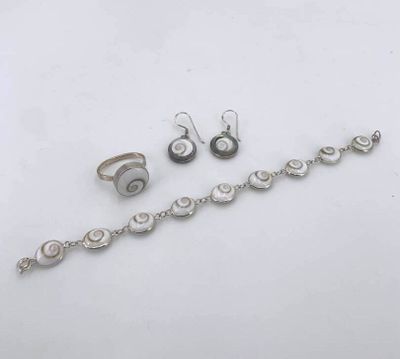 three pieces of silver jewelry sitting on top of a white surface