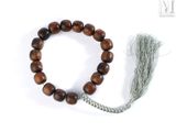 un gros plan d'un bracelet orné d'un pompon, posé sur une surface blanche