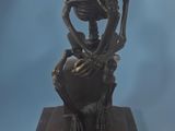 a statue of a skeleton sitting on top of a box