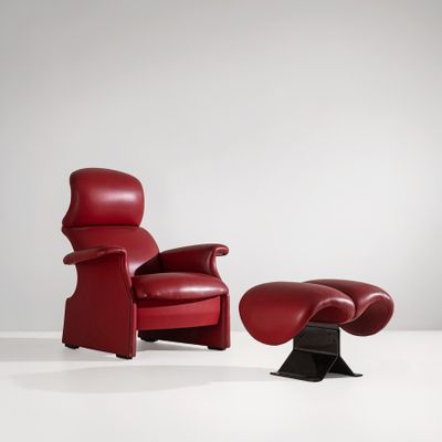un fauteuil en cuir rouge et un pouf dans une pièce blanche