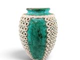 green and white ceramic vase with intricate design on white background